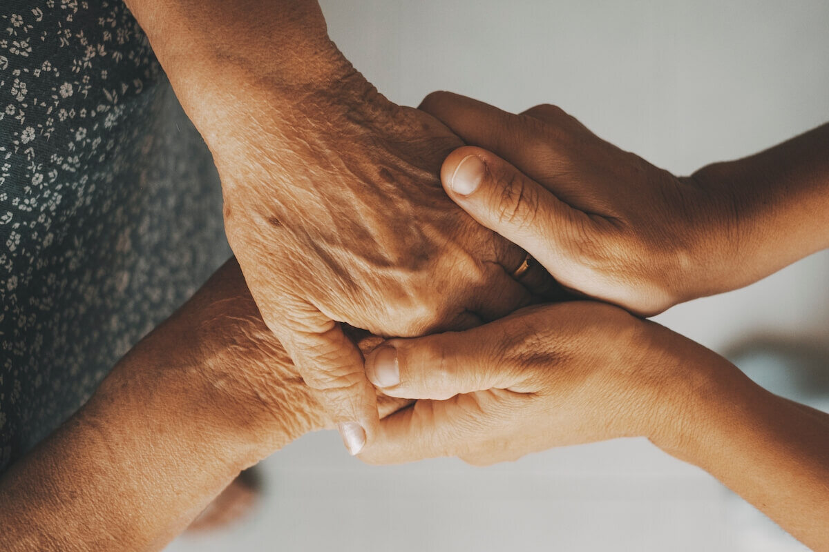 Caring elderly grandma wife holding hand supporting senior grandpa husband give empathy 