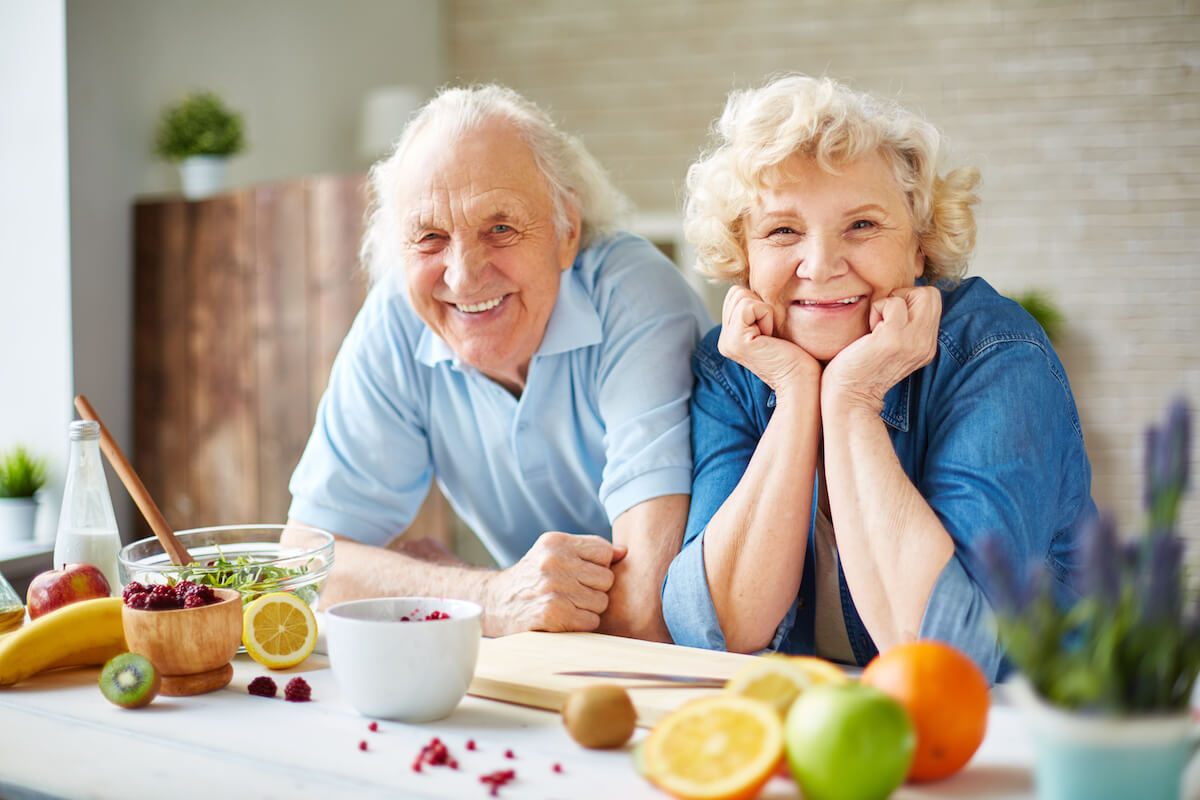 A happy senior couple prepares a meal with fresh ingredients_Brickmont Assisted Living